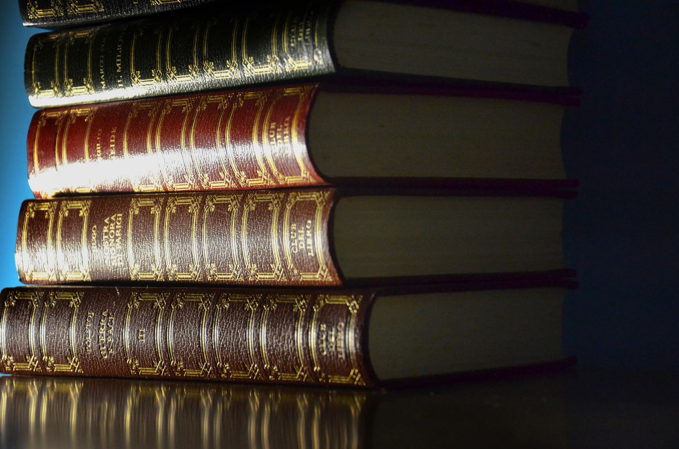 A stack of well-worn, gilded leather-bound books